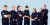 Seit­se­män varti­ja­o­pis­ke­li­jaa seisoo hymyillen rivis­sä vartijan uni­vor­mut päällä.